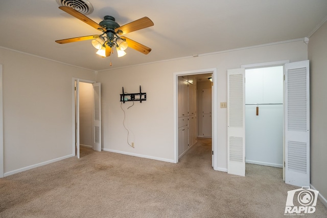 unfurnished bedroom featuring crown molding, ceiling fan, and light colored carpet