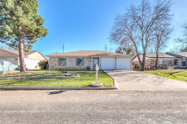 single story home with driveway, brick siding, an attached garage, and a front lawn