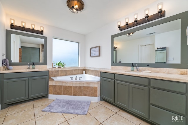 bathroom featuring tile patterned flooring, tiled tub, and vanity