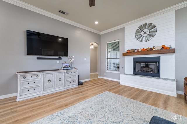 living room with crown molding, ceiling fan, and light hardwood / wood-style floors