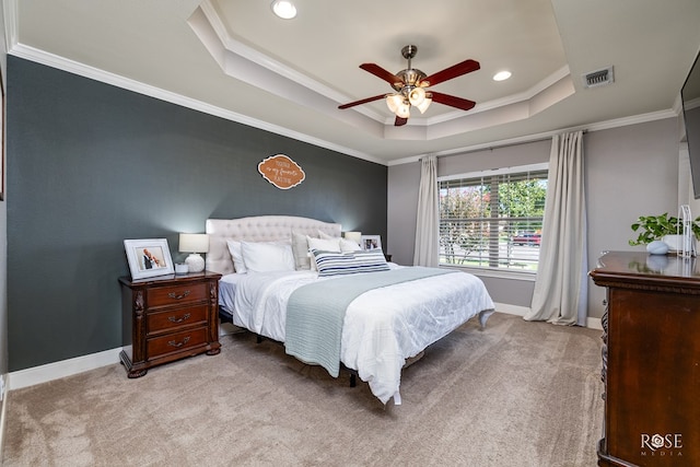 carpeted bedroom with crown molding, a tray ceiling, and ceiling fan