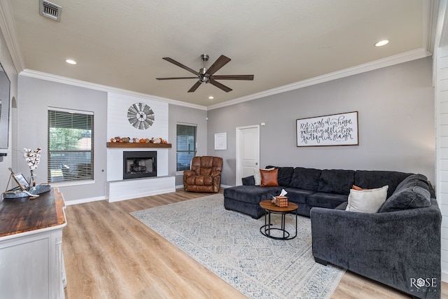 living room featuring crown molding, ceiling fan, and light wood-type flooring