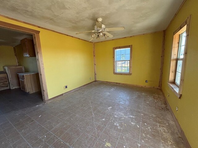 unfurnished room with ceiling fan and a healthy amount of sunlight