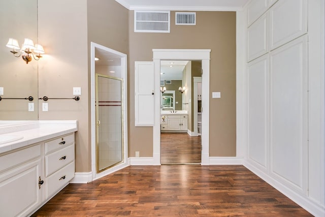 bathroom featuring hardwood / wood-style flooring, vanity, an enclosed shower, and a notable chandelier