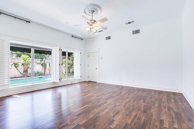 spare room with dark wood-type flooring and ceiling fan