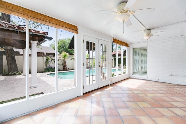 unfurnished sunroom with ceiling fan