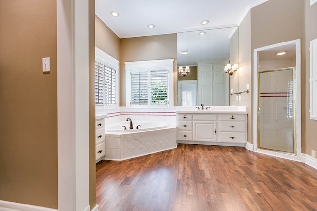 bathroom with hardwood / wood-style flooring, vanity, crown molding, and separate shower and tub