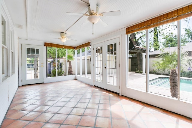 unfurnished sunroom with plenty of natural light, french doors, and ceiling fan