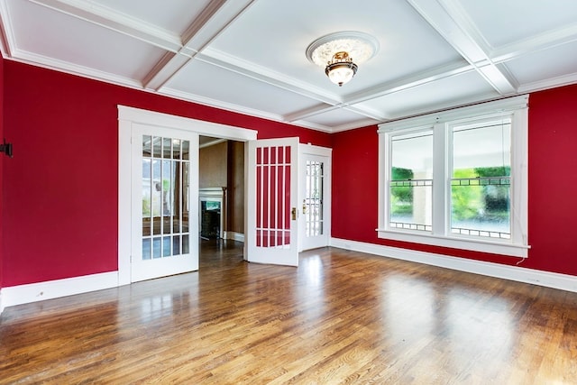 spare room featuring french doors, coffered ceiling, ornamental molding, beam ceiling, and hardwood / wood-style floors