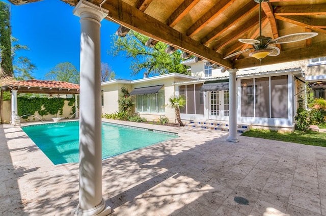 view of swimming pool featuring a sunroom, a patio, ceiling fan, and french doors