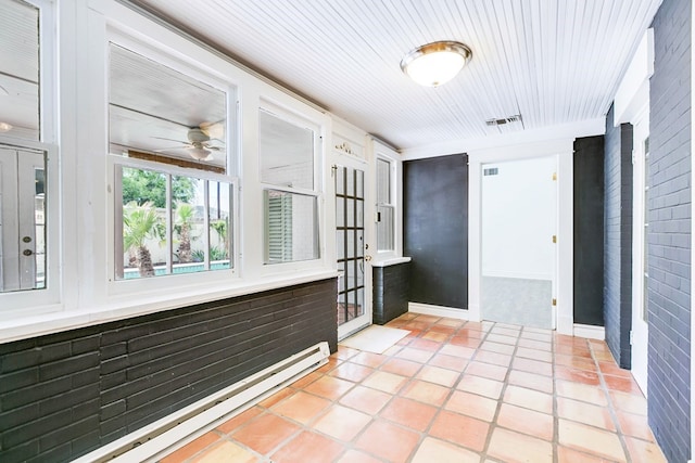 hallway with a baseboard heating unit and light tile patterned floors