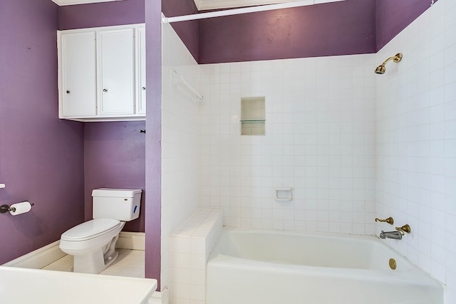 bathroom with tiled shower / bath, tile patterned floors, and toilet