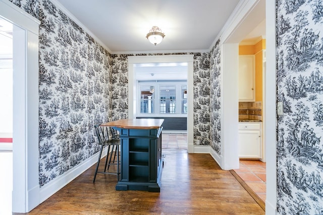 dining space featuring ornamental molding and dark hardwood / wood-style floors