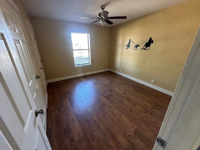 unfurnished bedroom with ceiling fan and dark hardwood / wood-style flooring