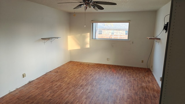 empty room with a ceiling fan, wood finished floors, and a textured ceiling