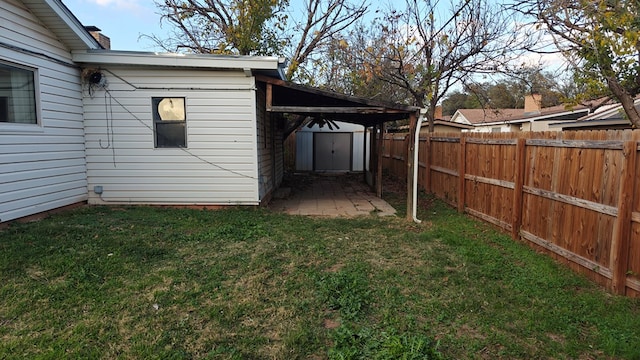 view of yard with a storage shed, an outbuilding, and a fenced backyard