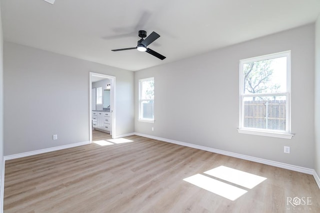 unfurnished bedroom with ceiling fan, ensuite bath, and light hardwood / wood-style flooring