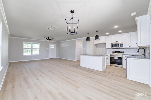 kitchen featuring sink, hanging light fixtures, appliances with stainless steel finishes, a kitchen island, and white cabinets