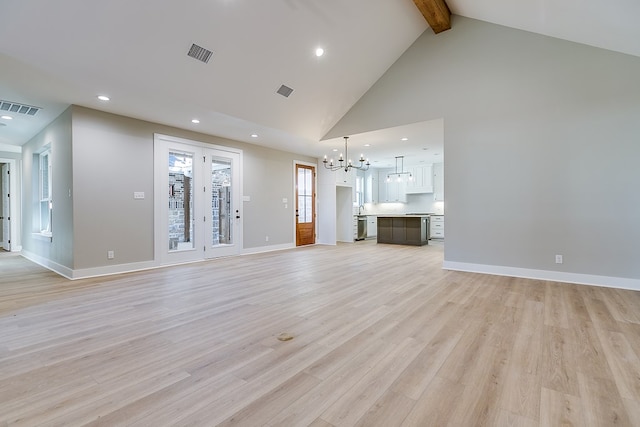 unfurnished living room with a notable chandelier, beam ceiling, light hardwood / wood-style flooring, and high vaulted ceiling