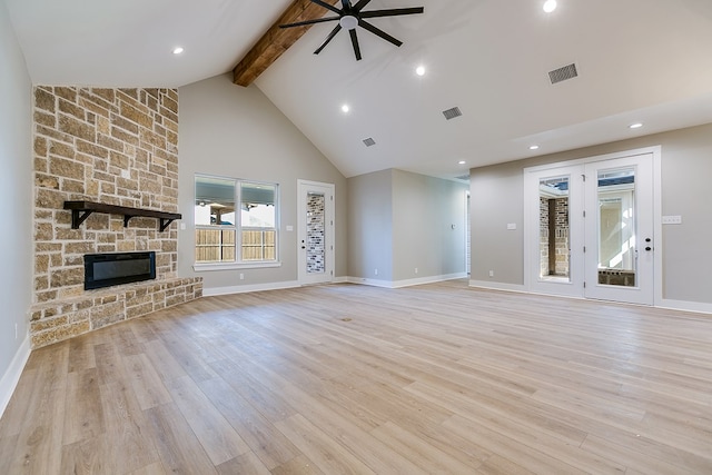 unfurnished living room featuring a stone fireplace, high vaulted ceiling, beamed ceiling, ceiling fan, and light wood-type flooring