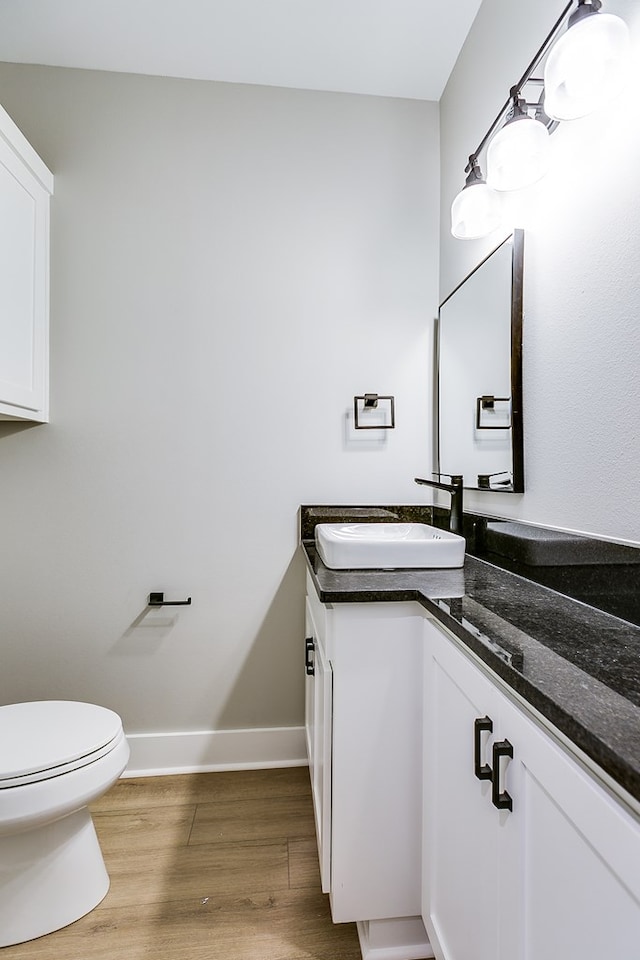 bathroom with vanity, hardwood / wood-style flooring, and toilet