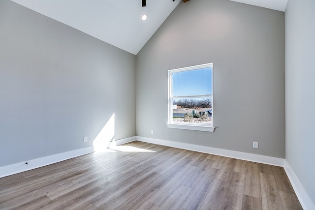 spare room with light hardwood / wood-style flooring and high vaulted ceiling