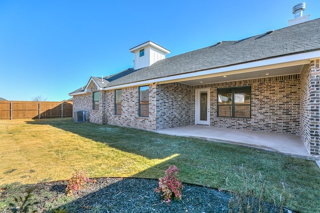 rear view of property featuring a yard, a patio area, and central air condition unit