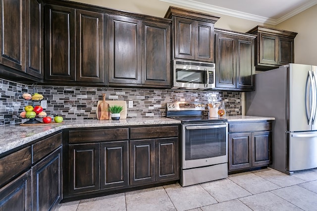 kitchen featuring appliances with stainless steel finishes, decorative backsplash, ornamental molding, light tile patterned floors, and dark brown cabinets