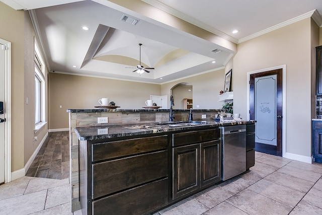 kitchen featuring sink, stainless steel dishwasher, a kitchen breakfast bar, a raised ceiling, and a kitchen island with sink