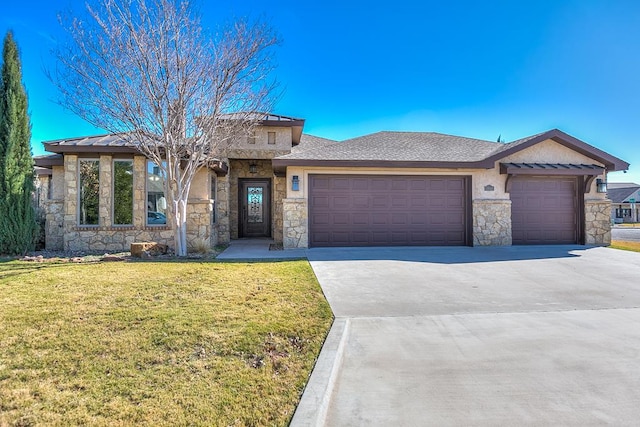 prairie-style home featuring a garage and a front lawn