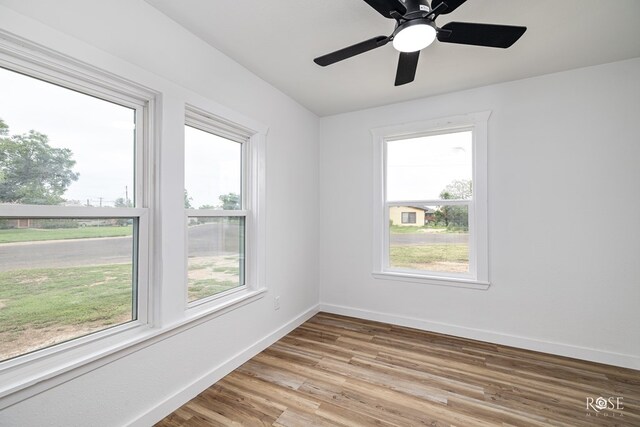 935 E 40th St, San Angelo, TX 76903 - empty room with plenty of natural light, light wood-style floors, and a ceiling fan