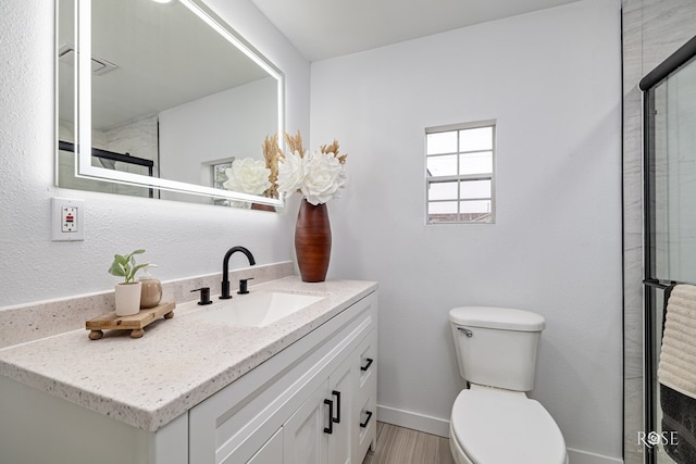 935 E 40th St, San Angelo, TX 76903 - bathroom featuring vanity, wood finished floors, and a shower with door