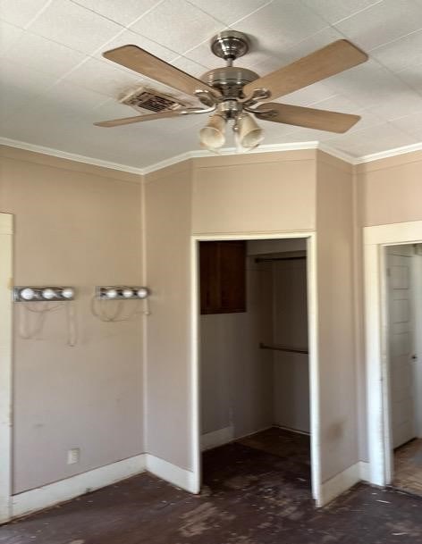 unfurnished bedroom featuring visible vents, a ceiling fan, a closet, crown molding, and baseboards