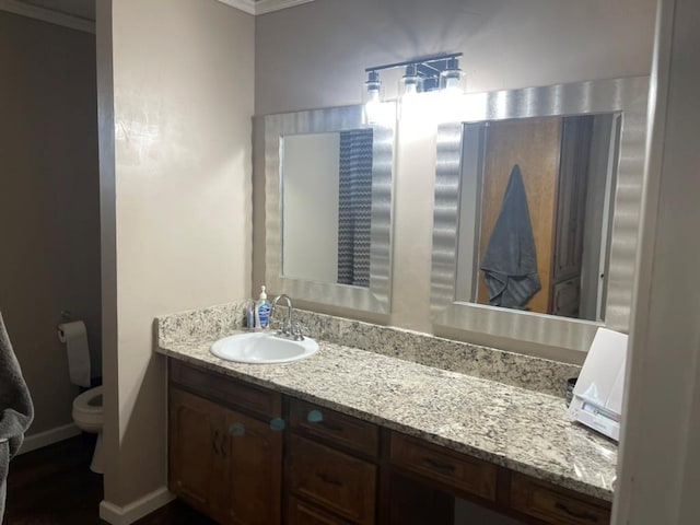 bathroom featuring vanity, ornamental molding, and toilet