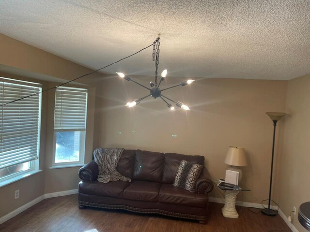 living room featuring wood-type flooring, a textured ceiling, and a notable chandelier