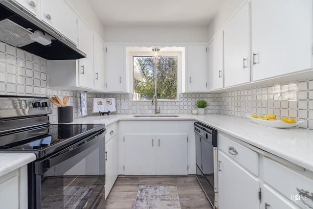 286 Mockingbird Ln, San Angelo, TX 76901 - kitchen featuring black appliances, a sink, under cabinet range hood, white cabinetry, and light countertops