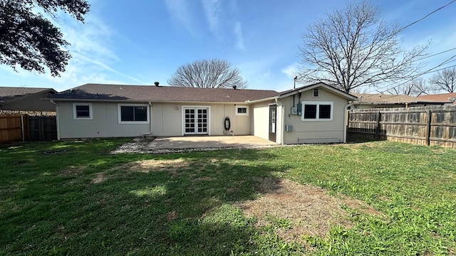 back of house featuring a patio area and a lawn