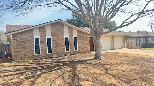 view of front of property featuring a garage and central AC unit