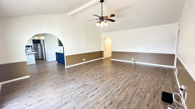 unfurnished room featuring hardwood / wood-style flooring, ceiling fan, and lofted ceiling with beams