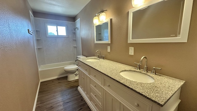 full bathroom featuring wood-type flooring, toilet, tiled shower / bath combo, and vanity