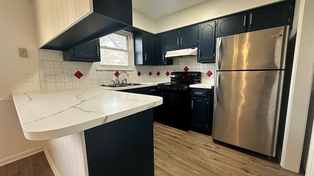 kitchen featuring sink, light wood-type flooring, stainless steel fridge, kitchen peninsula, and black range with electric stovetop