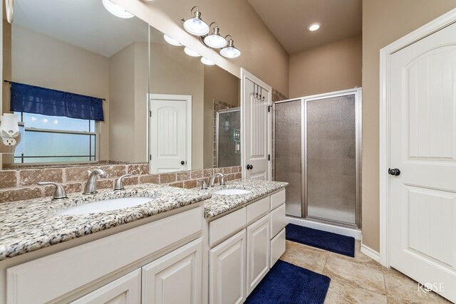 bathroom featuring vanity, a shower with shower door, and tile patterned flooring