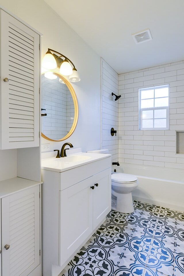 full bathroom with tiled shower / bath combo, vanity, and toilet