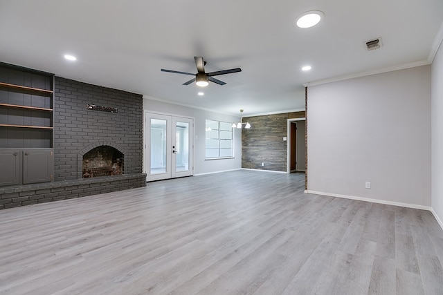 unfurnished living room with light hardwood / wood-style flooring, ceiling fan, ornamental molding, a brick fireplace, and french doors