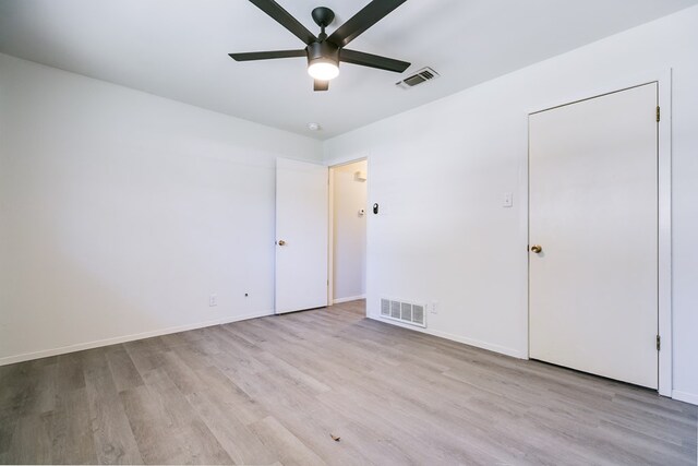 empty room with ceiling fan and light hardwood / wood-style flooring