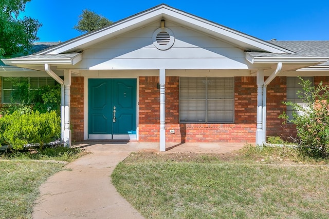 property entrance with a porch and a lawn