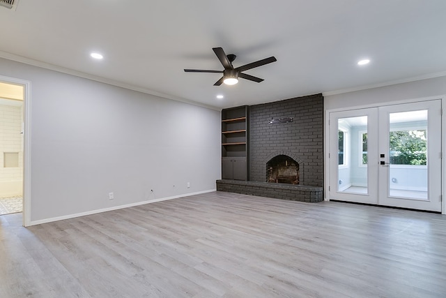 unfurnished living room with a fireplace, light hardwood / wood-style flooring, ornamental molding, ceiling fan, and french doors