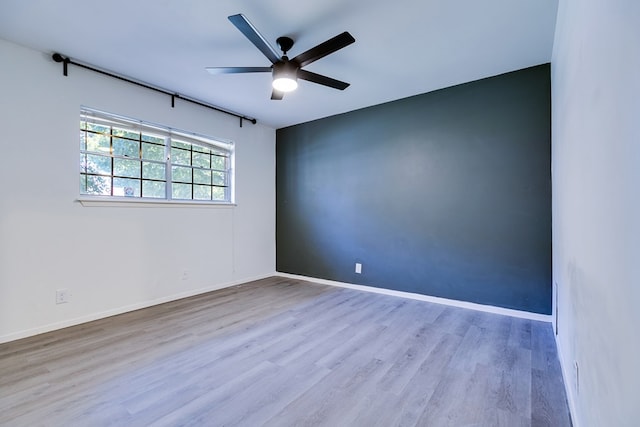 empty room with light hardwood / wood-style floors and ceiling fan