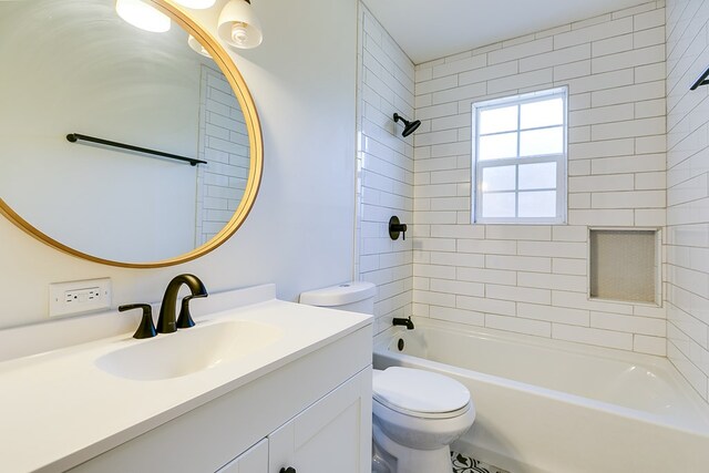 full bathroom featuring vanity, tiled shower / bath combo, and toilet