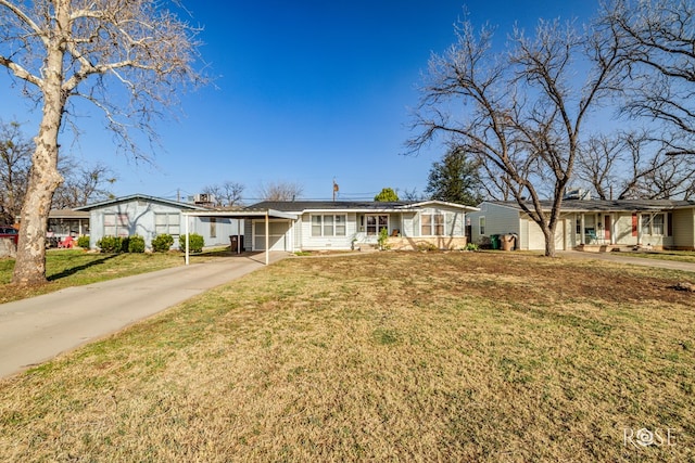 ranch-style house featuring a front yard and concrete driveway